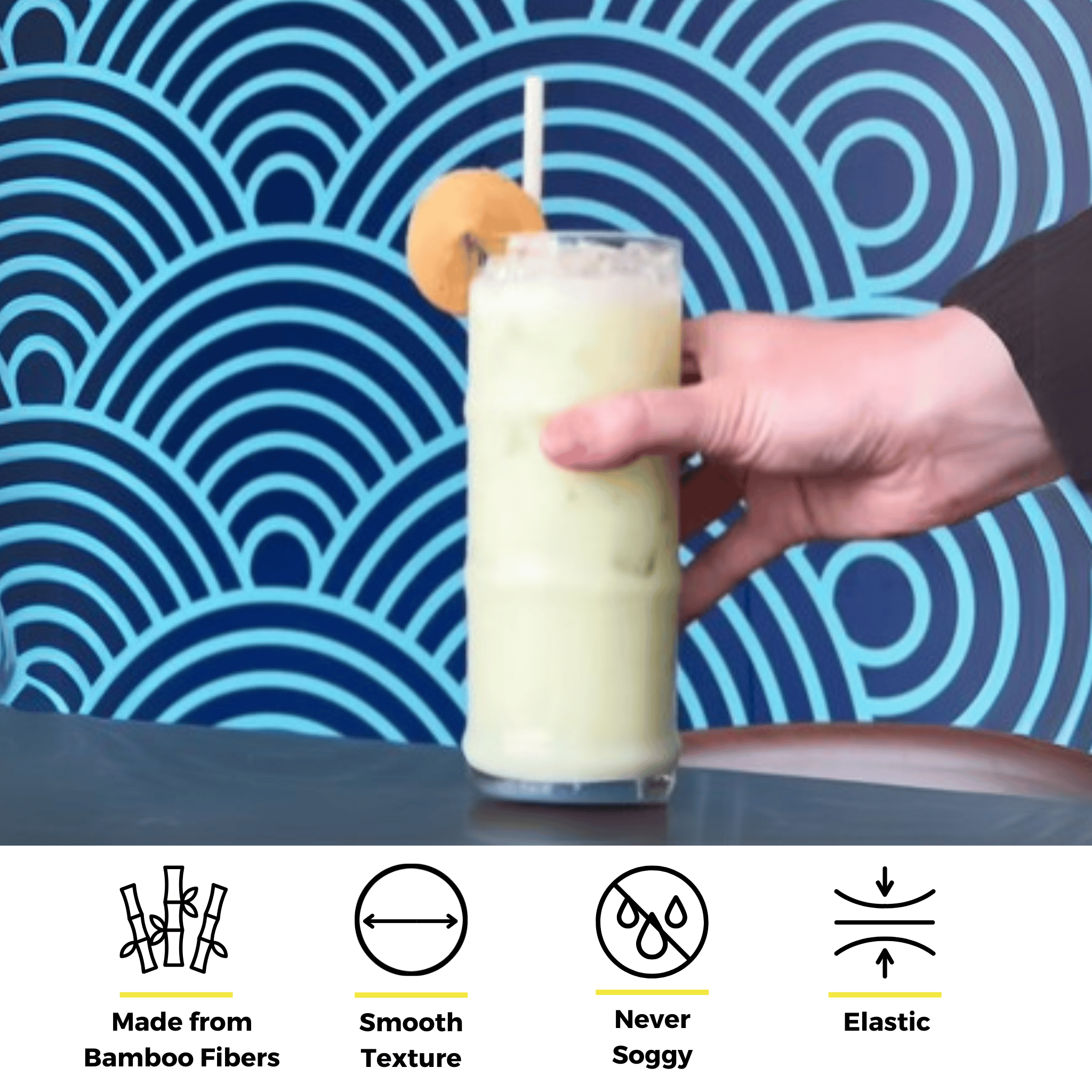 Hand holding a tall green smoothie with a bamboo fiber straw and a cookie garnish, set against a bold blue wave pattern background with icons showcasing the straw’s features—never soggy, elastic, and smooth texture.