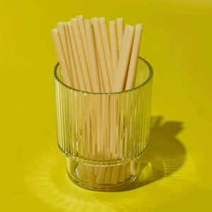 Glass filled with cocktail bamboo fiber drinking straws. 