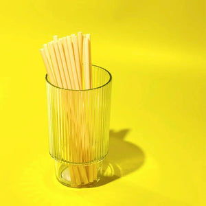 Glass filled with tall bamboo fiber drinking straws. 