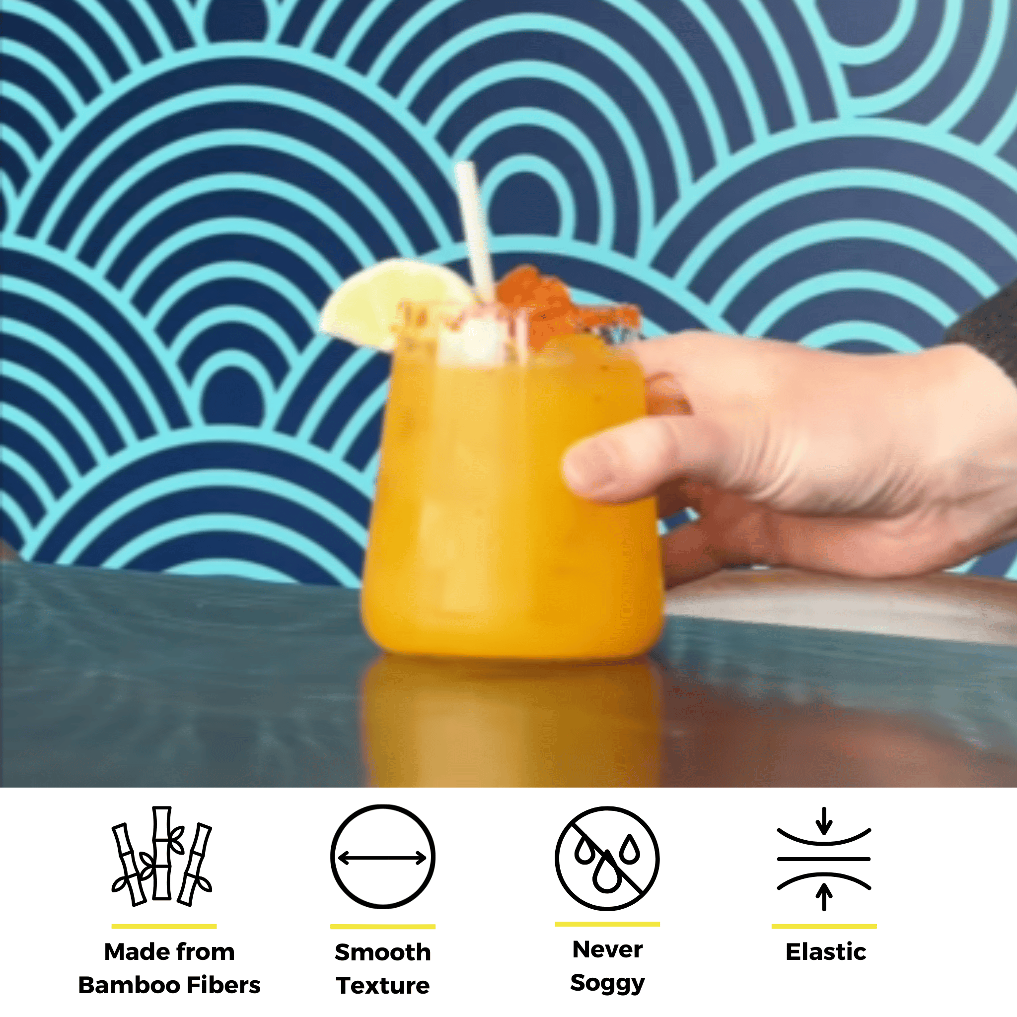 Hand holding a glass of orange drink with a lime wedge and bamboo fiber straw, shown above icons highlighting features like smooth texture, elasticity, anti-sogginess, and bamboo fiber composition.