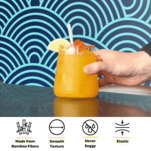 Hand holding a glass of orange drink with a lime wedge and bamboo fiber straw, shown above icons highlighting features like smooth texture, elasticity, anti-sogginess, and bamboo fiber composition.