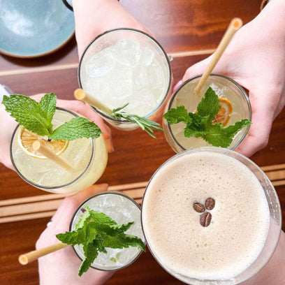 Overhead cheers of multiple drinks with wheat stem straws