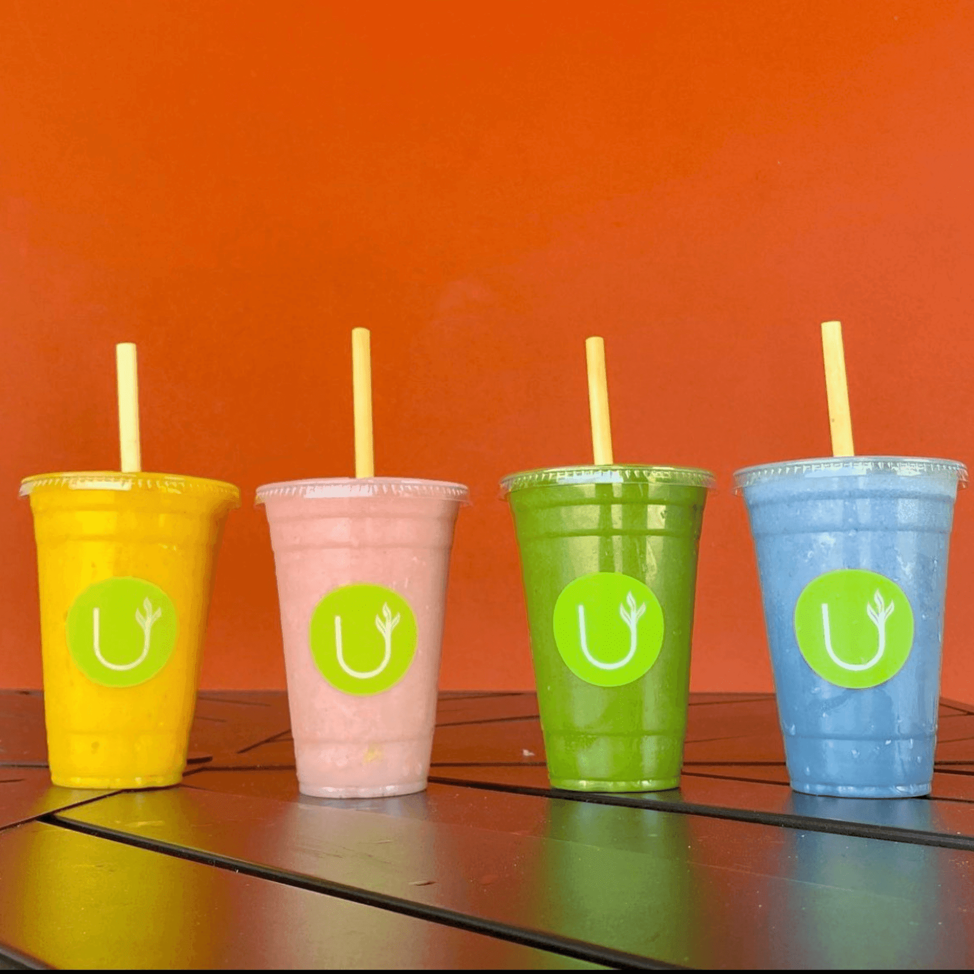lineup of four juices with sustainable straws